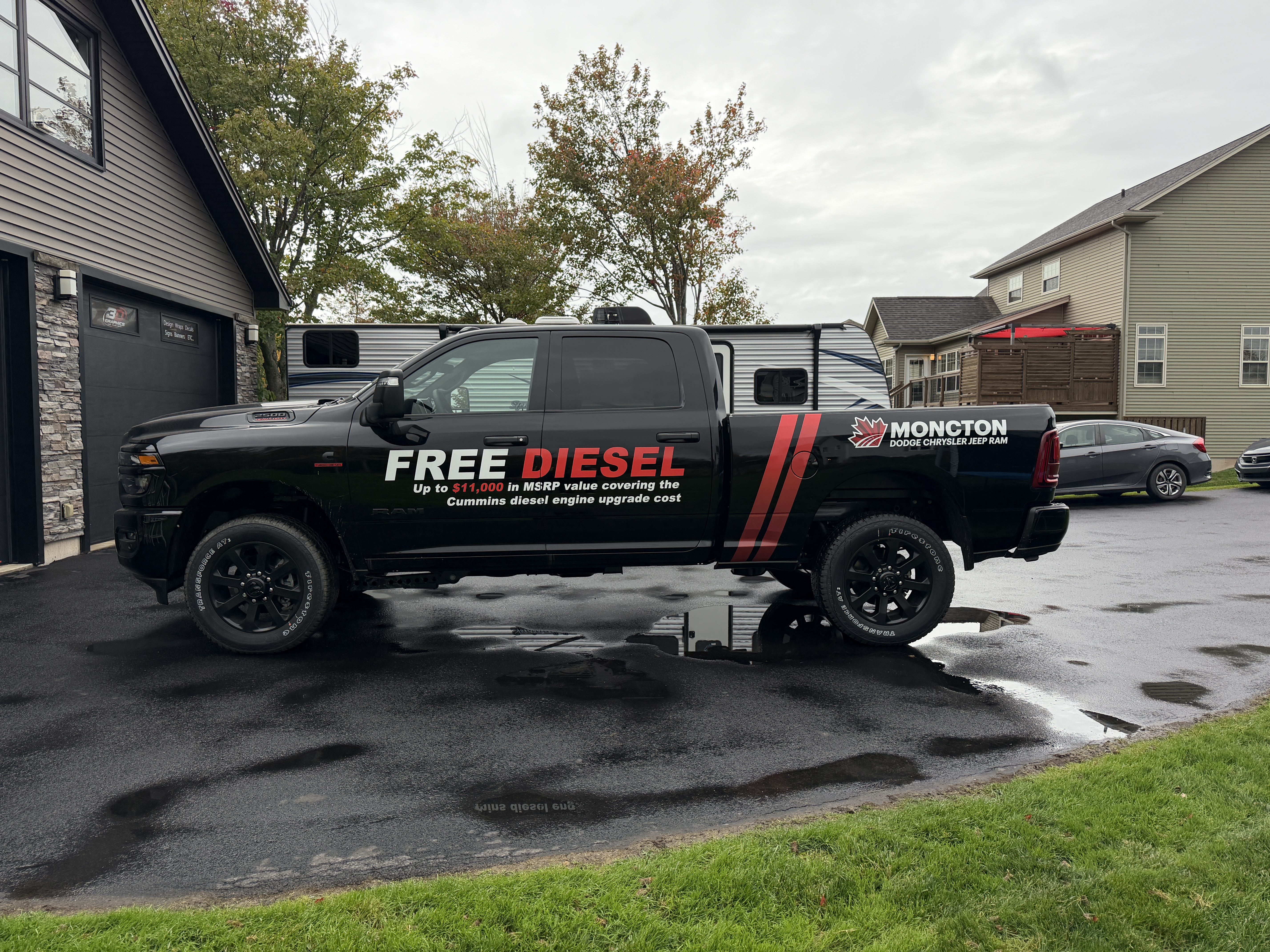 Black Moncton Chrysler truck with promotional vinyl graphics