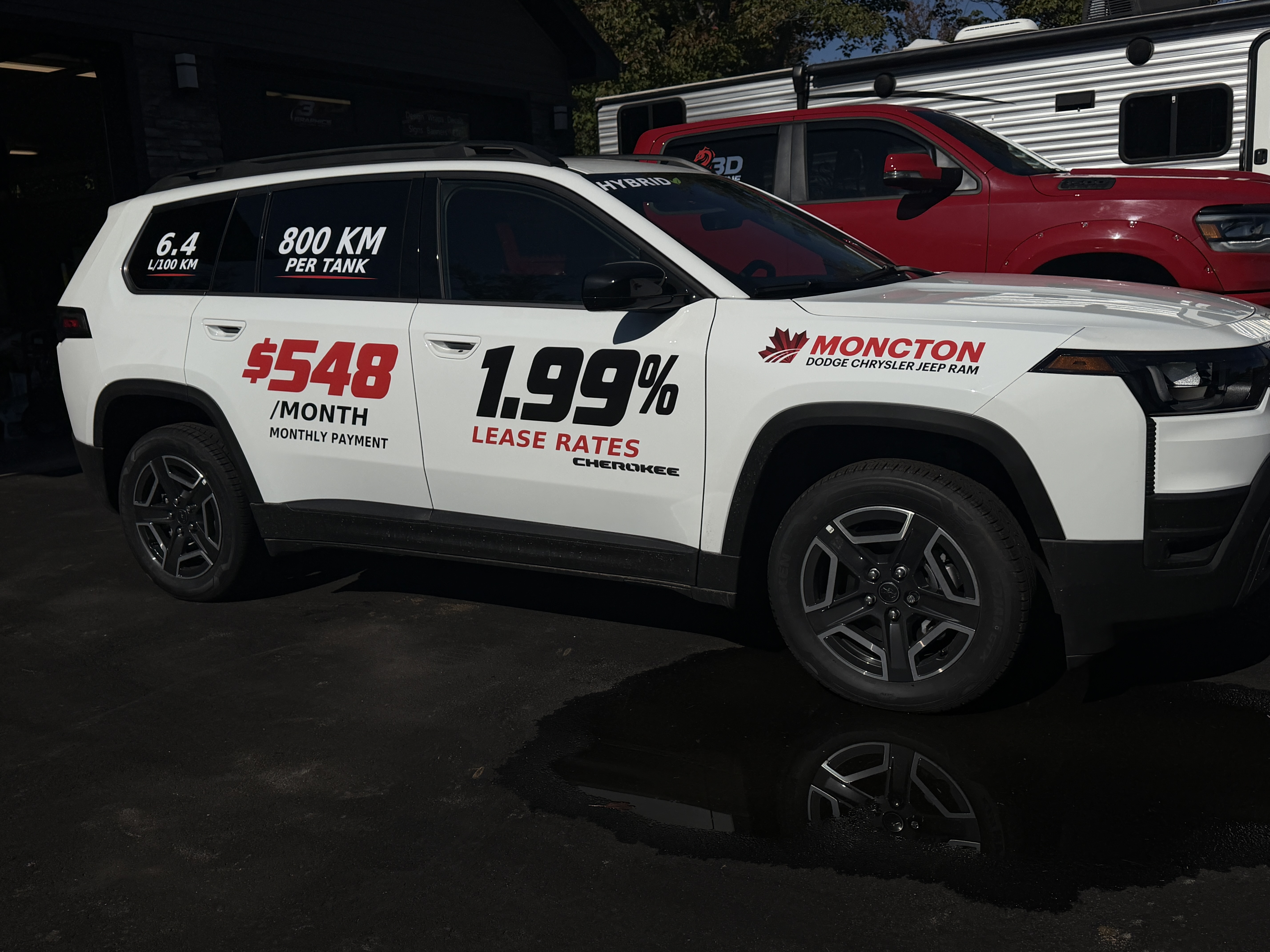 White Moncton Chrysler SUV with promotional vinyl lettering